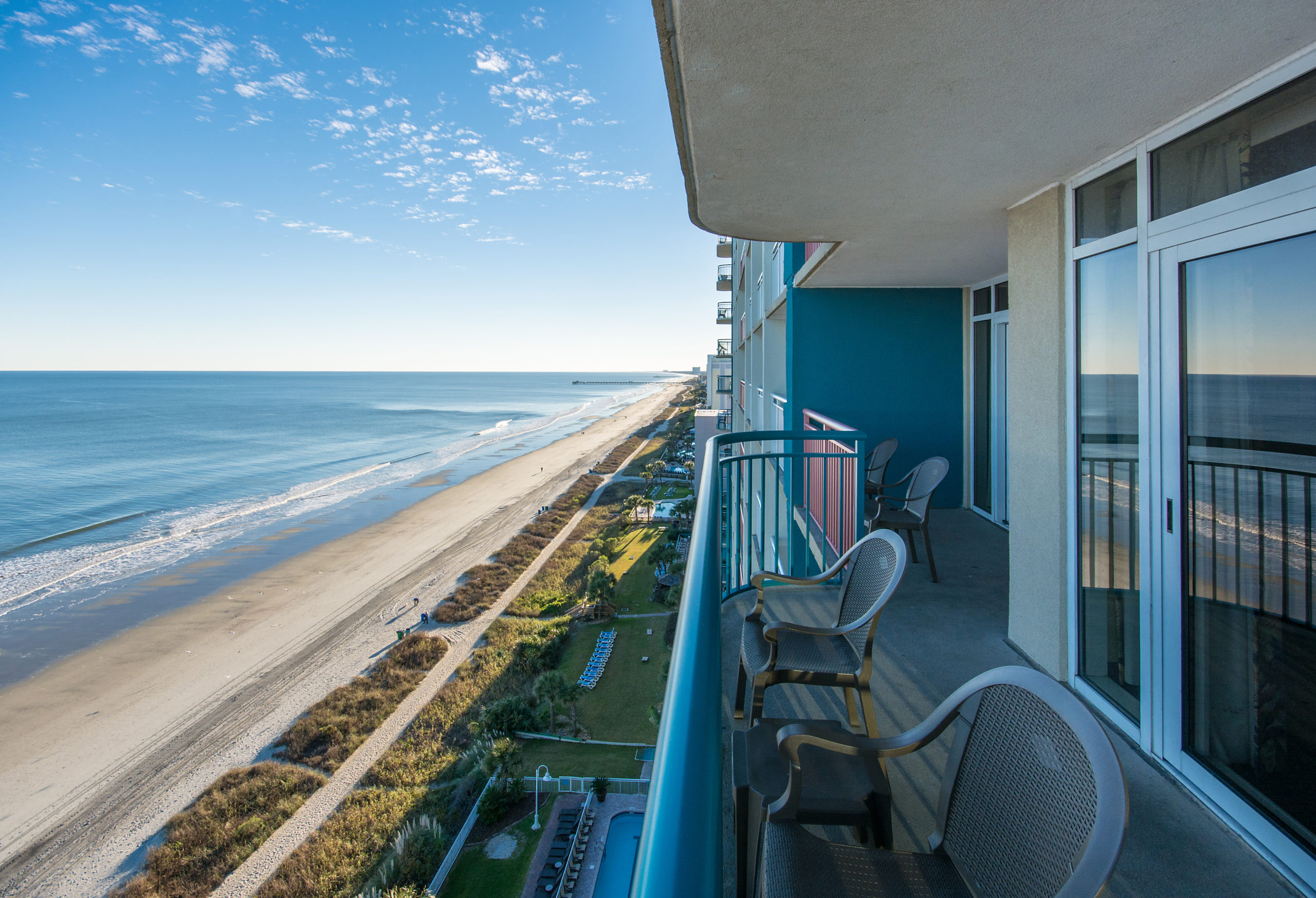 A balcony with a view of the ocean and beach