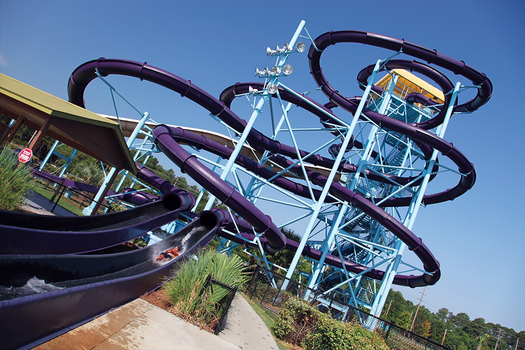 A large purple water slide with a tower in the background.