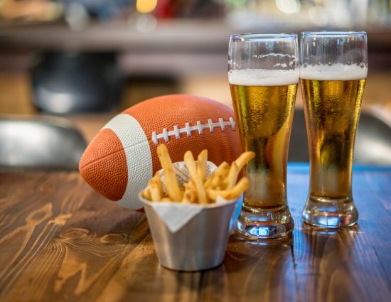 Watching a football game at a sports bar having drinks and eating snacks